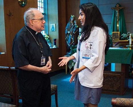 Daliha Aqbal speaks with Medical Center chaplain Fr. Sal Jordan, S.J. In the Med-Dent chapel.