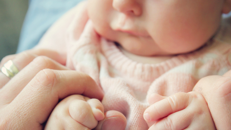 adult hand holding baby