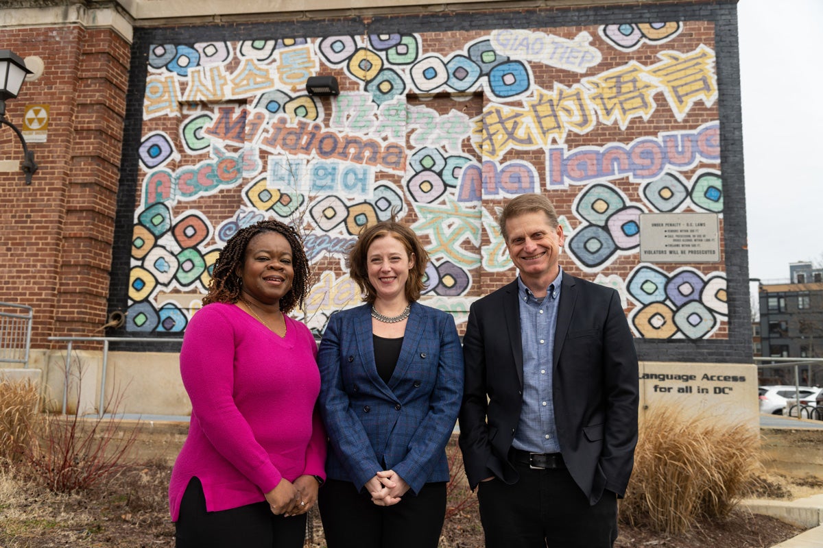 Professors Sabrina Wesley-Nero (SFS’95), Crissa Stephens, and Douglas Reed, the principal investigators of Project ELEECT, stand before the “Language Access for All in D.C.” mural created by Criomatic Muralist Juan Pineda in partnership with D.C.’s Office of Latino Affairs.
