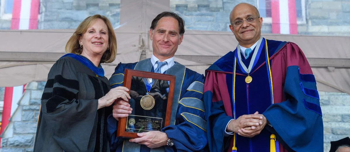 Joe Baratta, at center, was a commencement speaker for the McDonough School of Business in 2019. His remarks highlight the “hard work, humility, and honesty” of Georgetown graduates. After the ceremony, he received the Dean’s Medal for his service to the school.
