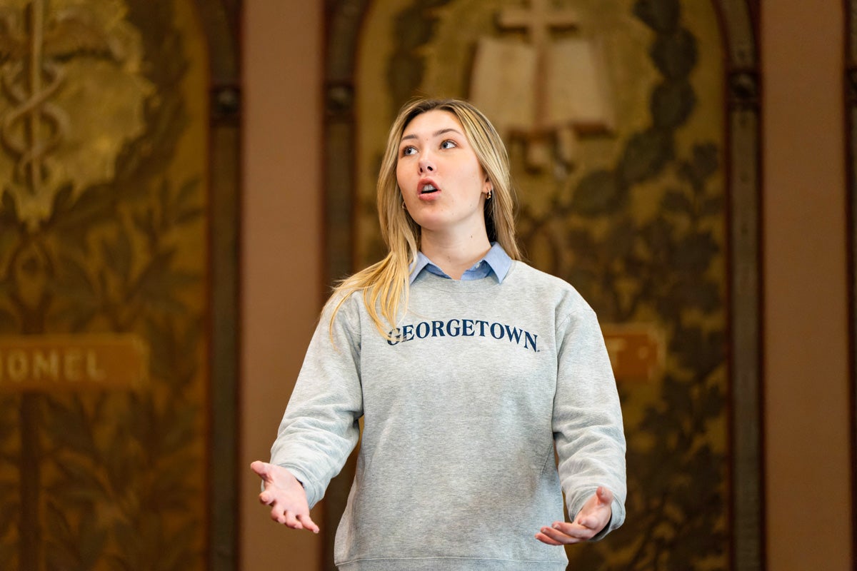 a student wearing a Georgetown shirt sings