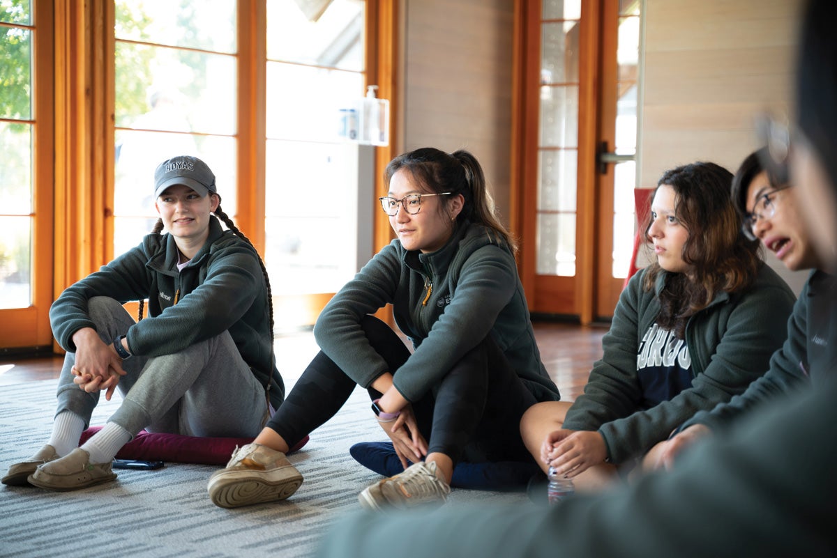 students sit on the floor next to each other in an open building