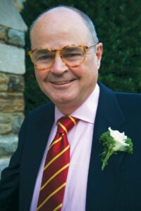 a man in a suit with glasses and a red and yellow striped tie 