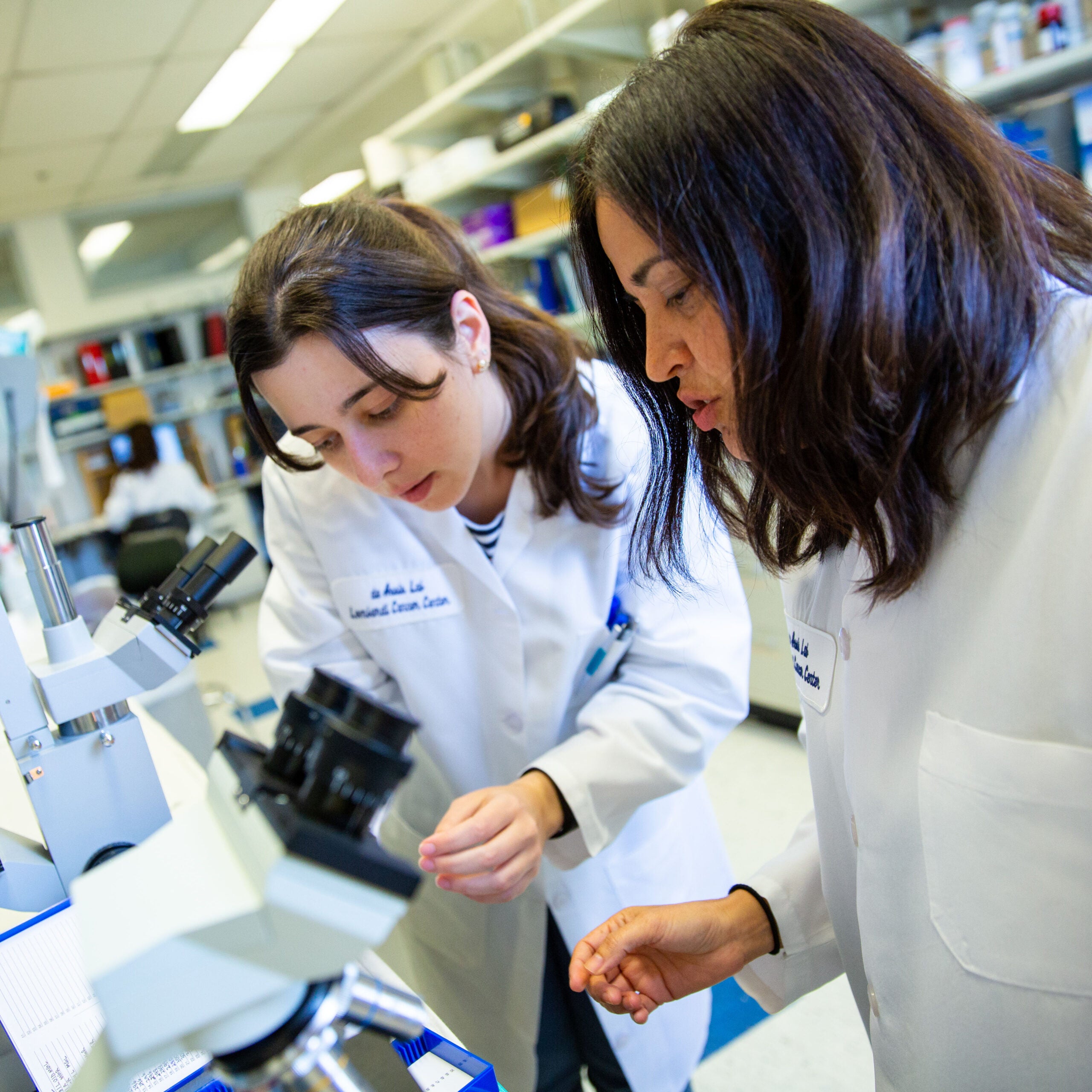 people in lab with microscope