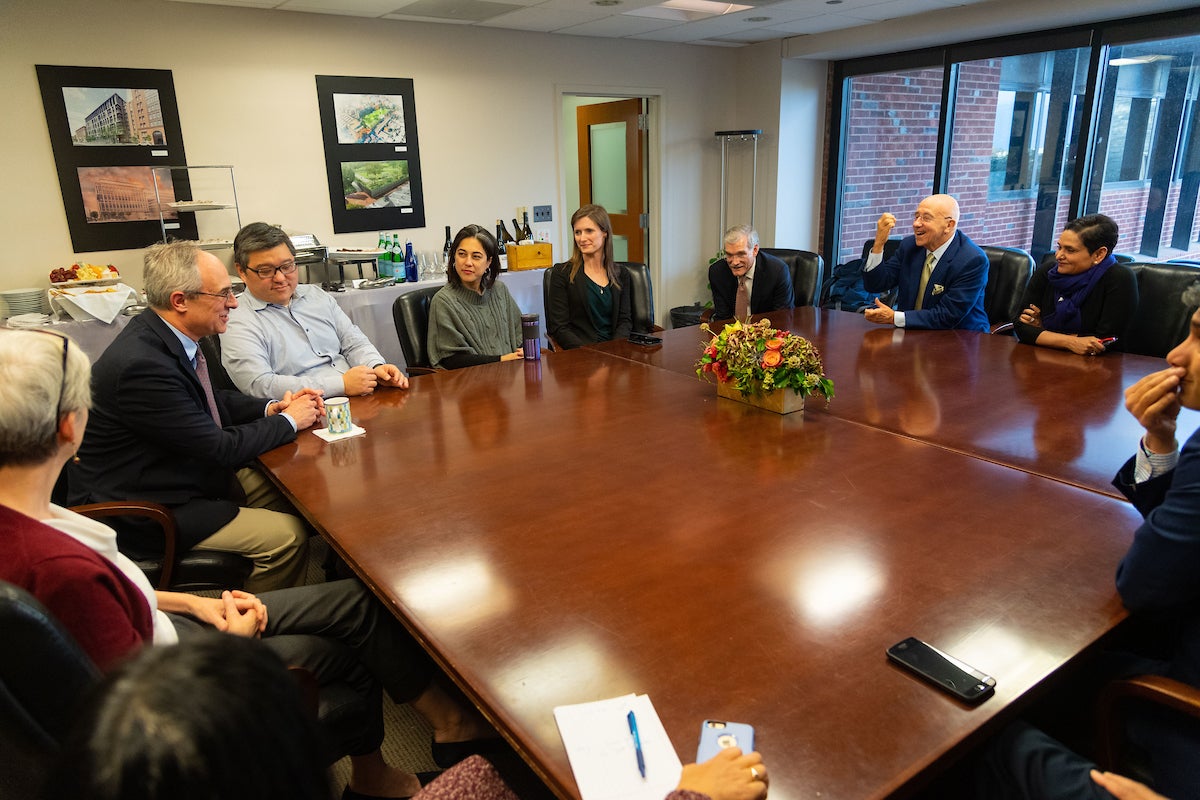 Lynn and Fritz meeting with university leaders around a large table