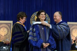 NHS Dean Patricia Cloonan and President John J. DeGioia present Luci Baines Johnson with an honorary Georgetown University academic hood in 2018.